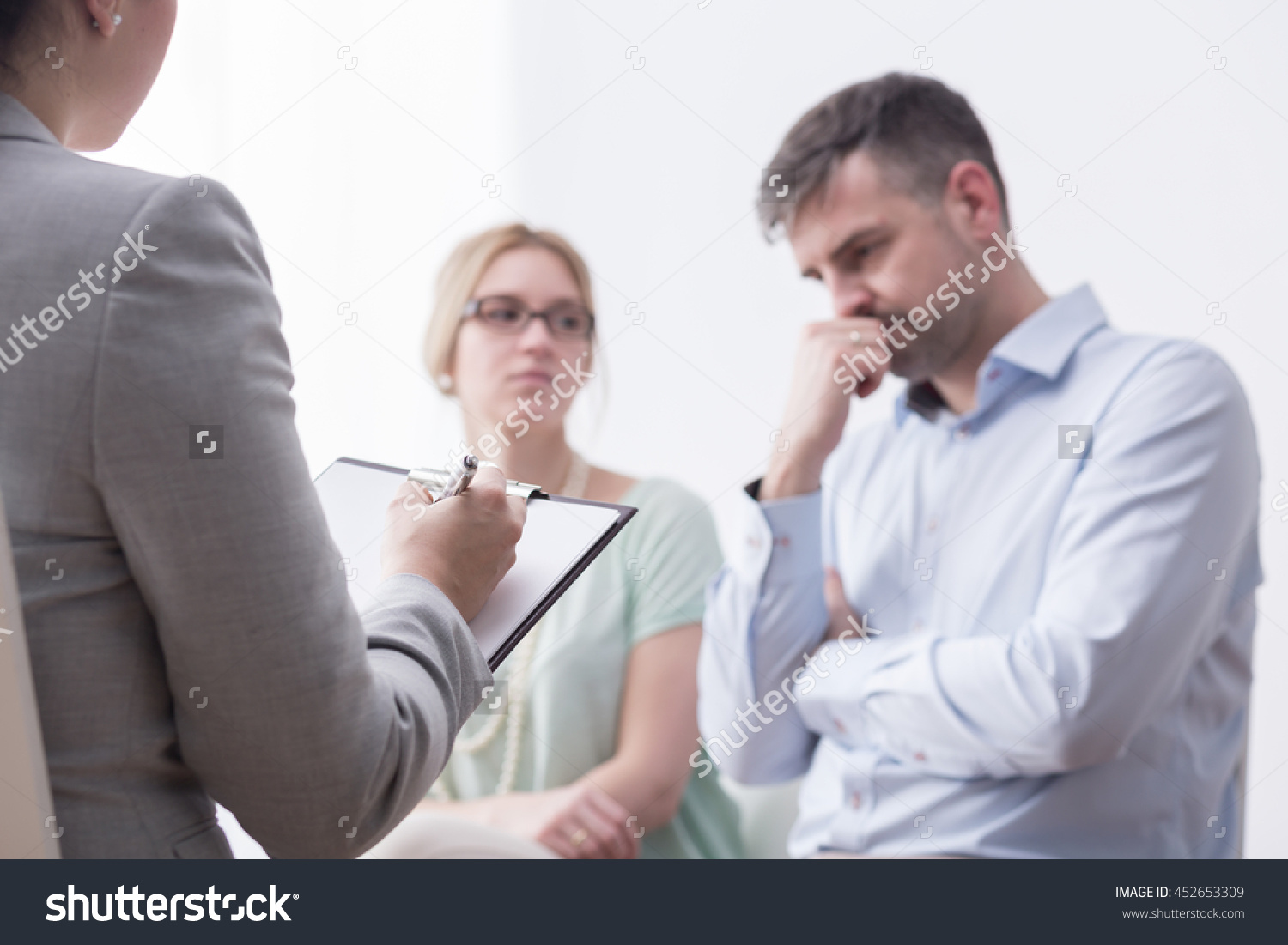 stock-photo-shot-of-a-female-therapist-taking-notes-during-the-meeting-with-a-young-marriage-452653309